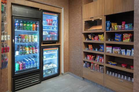 Hotel snack shop with beverage coolers and shelves stocked with snacks and beverages