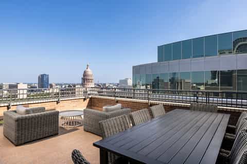 Upscale rooftop terrace with city views of capitol building and wicker furniture
