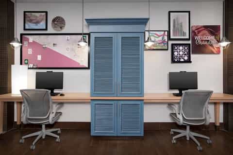 Modern business center with two workstations, blue storage cabinet, and contemporary lighting