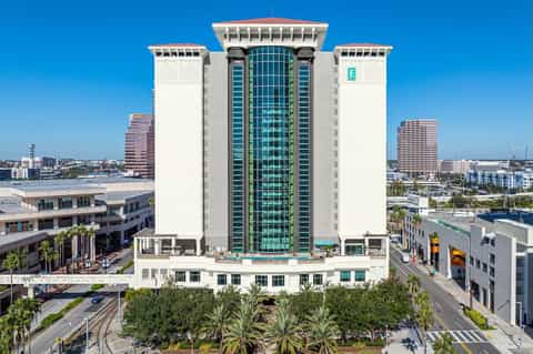 Contemporary Hilton hotel tower with distinctive green glass center and white stone facade