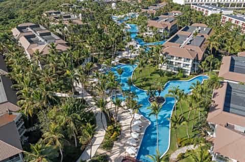 Aerial view of tropical resort with multiple blue pools and palm tree landscaping