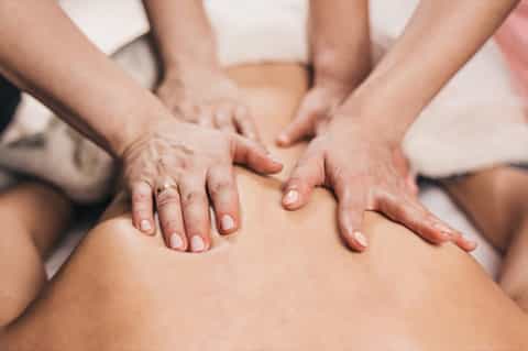 Close-up of therapeutic massage session with hands performing back treatment on client
