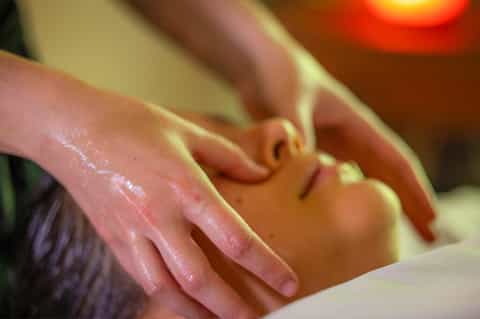 Close-up of spa massage treatment with therapist's hands on client's shoulder