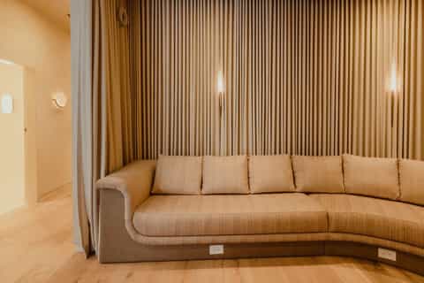 Curved beige upholstered sectional sofa in warm-toned contemporary living space