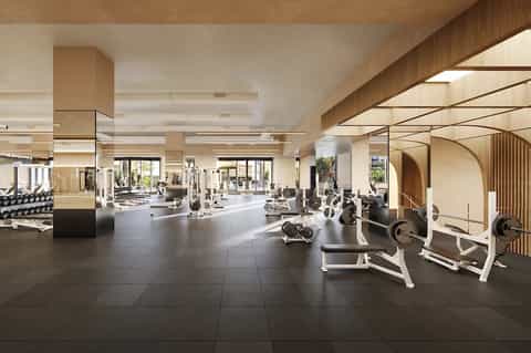 Spacious modern fitness center with cardio equipment, weights, and bright natural lighting throughout