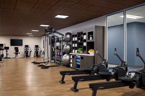 Modern hotel fitness center with exercise bikes, equipment, and storage shelving