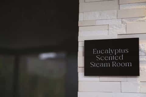 Entrance sign reading 'Eucalyptus Scented Steam Room' at elegant spa facility