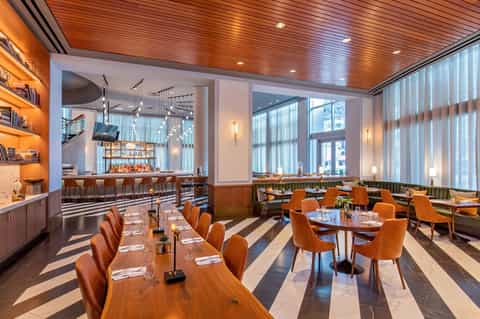 Restaurant dining room with wood ceiling, bar, and city views