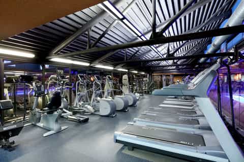 State-of-the-art fitness center with treadmills, cardio equipment, and modern industrial ceiling design