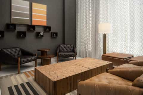 Modern spa relaxation lounge with black leather seating, wood tables, and neutral decor