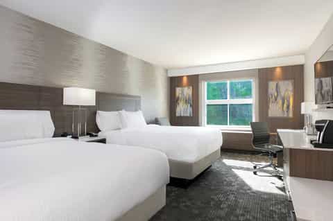 Contemporary hotel guest room with two queen beds and modern furnishings