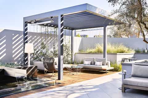 Modern rooftop terrace with pergola, outdoor seating, planters, and contemporary furniture design