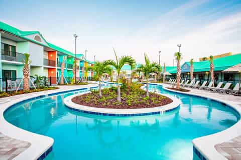 Turquoise resort pool with palm trees and colorful building architecture