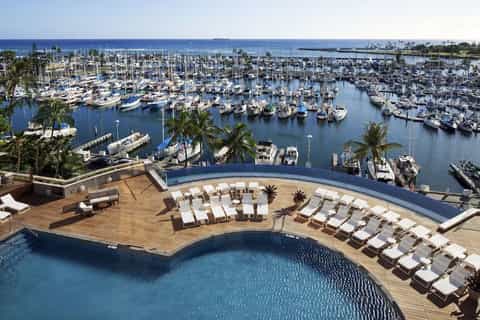 Resort pool deck overlooking marina filled with sailboats and palm trees