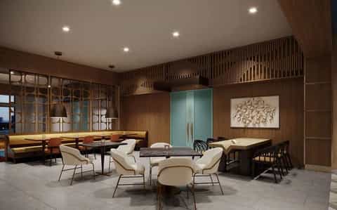Upscale hotel lounge with wood paneling, cream chairs around marble table, and ambient lighting throughout spacious room