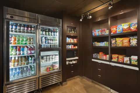 24-hour convenience shop with refrigerated beverage cases and stocked snack shelving
