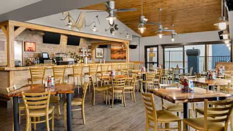 Casual dining restaurant with wooden tables, ladder-back chairs, exposed wood beams and outdoor views