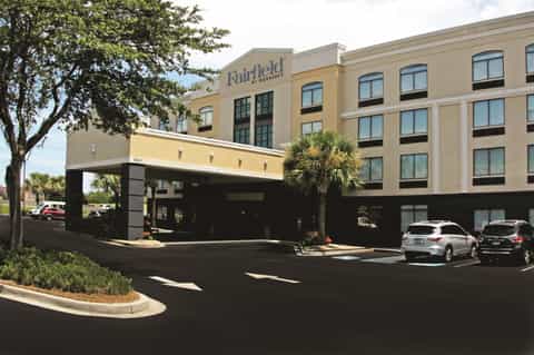 Fairfield by Marriott front entrance with covered driveway, parking area, and palm trees