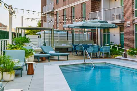Luxury resort poolside with lounge chairs, umbrellas, and architectural backdrop