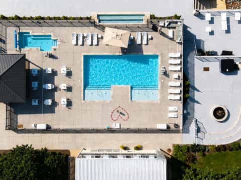 Overhead view of resort pool complex with lounge chairs and surrounding buildings