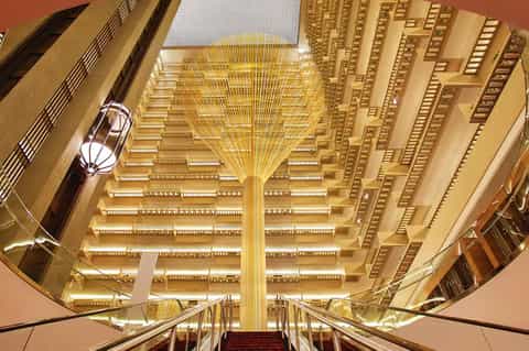 Grand hotel atrium with ornate golden ceiling and symmetrical architectural design