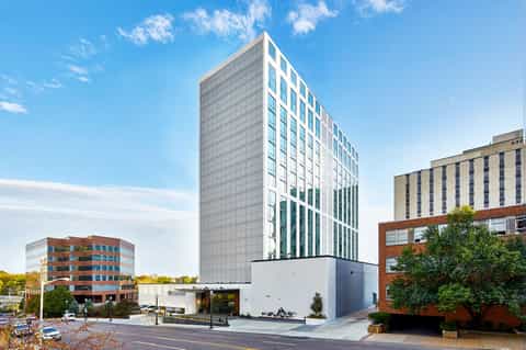 Modern multi-story hotel building with white and gray facade in urban setting