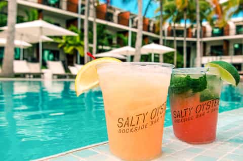 Tropical poolside cocktails at Salty Oyster Dockside Bar with resort in background