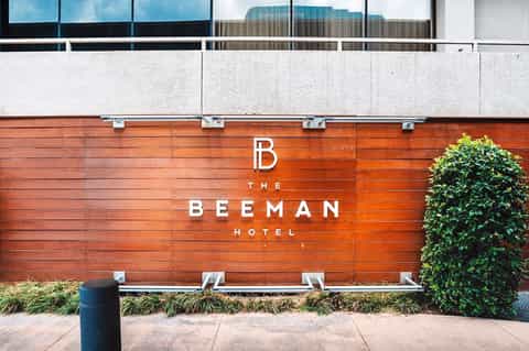 The Beeman Hotel exterior sign on wooden wall with ivy and landscaping