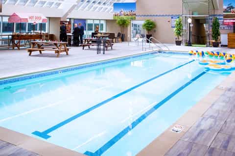 Indoor Olympic-size swimming pool with lane dividers, lounge area, and spectator seating