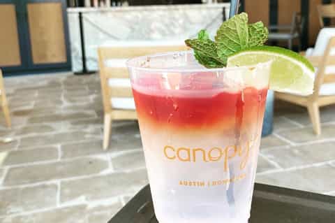 Red tropical cocktail with lime and mint at Canopy hotel in Austin Downtown
