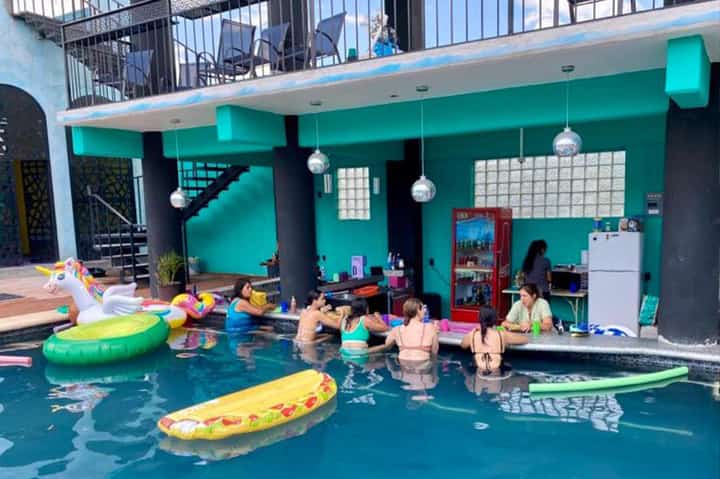 Indoor children's swimming pool with colorful floats and instructor supervision