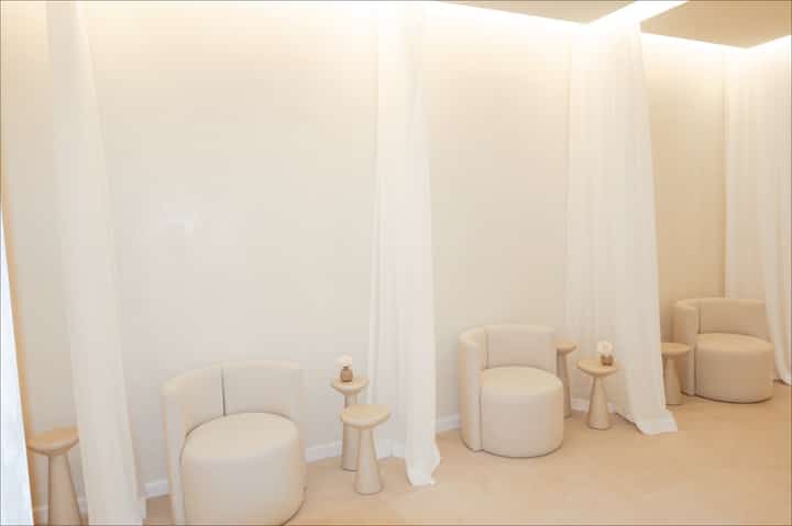 Spa relaxation area with cream-colored curved seating pods separated by curtains
