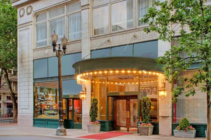 Historic hotel entrance with illuminated carousel-style canopy and elegant facade