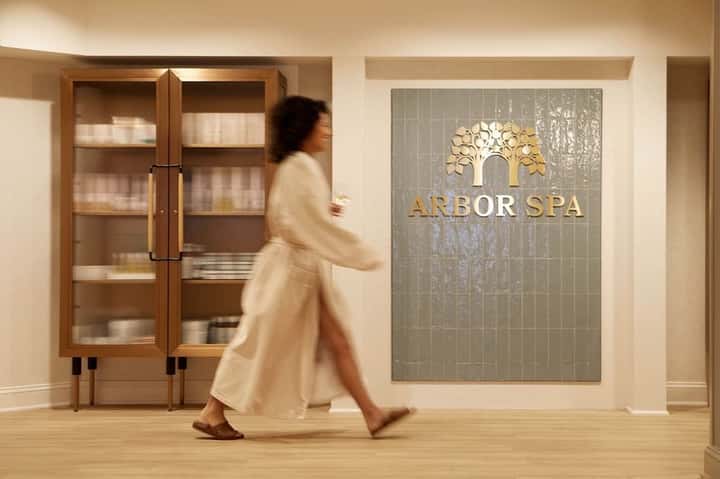 Arbor Spa entrance with wooden doors and decorative tree logo signage on wall