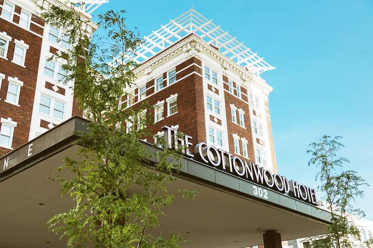 The Cottonwood Hotel exterior with brick facade, white trim, and decorative roofline