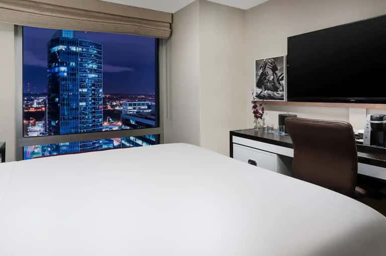 Hotel bedroom with city skyline night view through floor-to-ceiling window