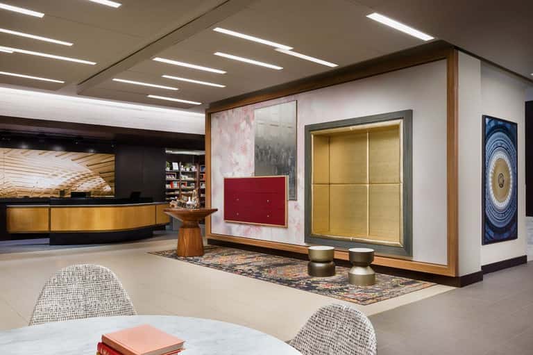 Modern hotel lobby with curved reception desk, artwork displays, and contemporary furnishings