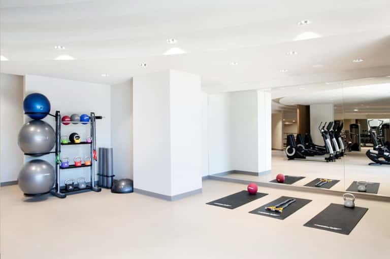 Modern fitness center with exercise equipment, stability balls, and mirrors