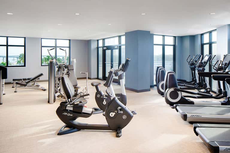 Modern gym facility with stationary bikes, treadmills, and exercise equipment with ocean views