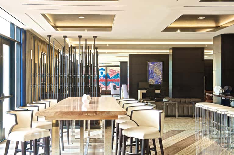 Modern dining area with wooden table, white chairs, and geometric wall art