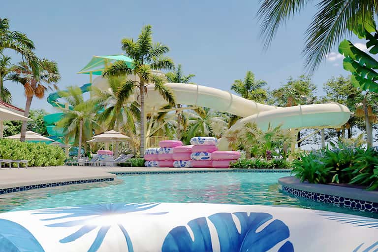 Resort pool with water slides, tropical palm trees, and pink inflatable floats