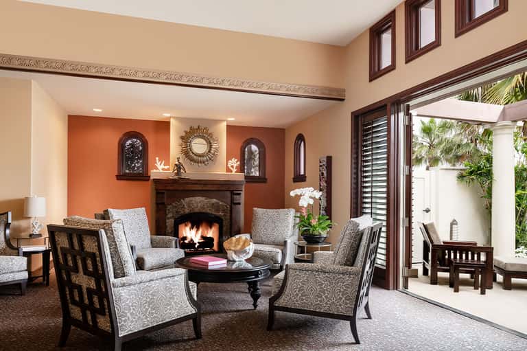 Elegant living room with orange accent walls, fireplace, and modern furnishings