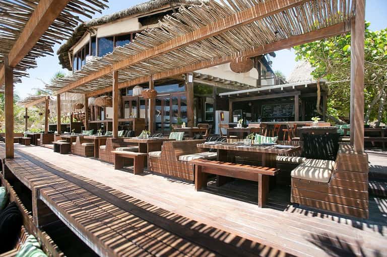 Wooden pergola outdoor dining area with wicker furniture and ocean views