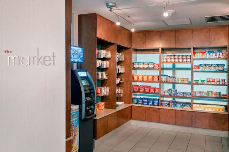 Convenience store interior with wooden shelving, stocked shelves, and ATM machine