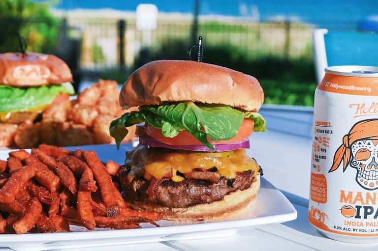 Gourmet burger with lettuce, tomato, and cheese served with crispy fries and craft beer