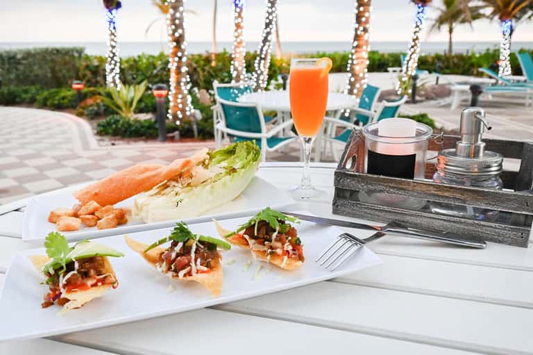 Upscale beachside dining with lobster roll, appetizers, and ocean view from terrace