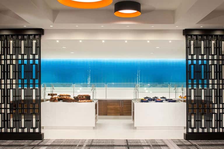 Modern bakery display case with ocean-view windows, featuring baked goods and pastries