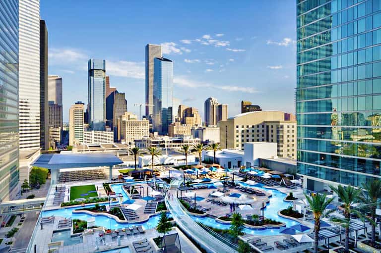 Aerial view of downtown Houston skyline with resort pool complex featuring water slides and lounging areas