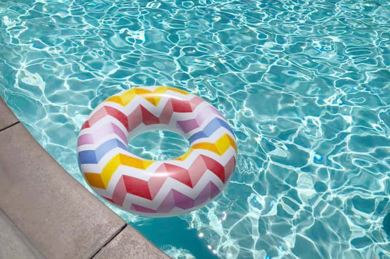 Colorful striped pool float in crystal-clear turquoise swimming pool water
