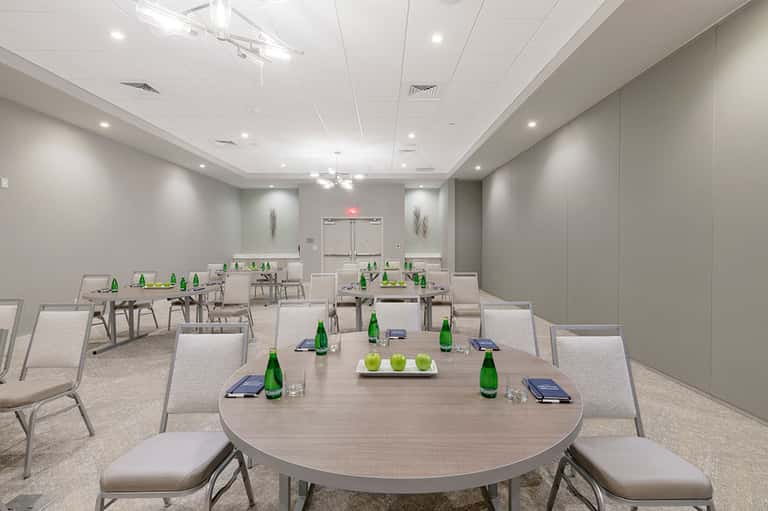Conference room with round tables set up for business meetings with green bottles